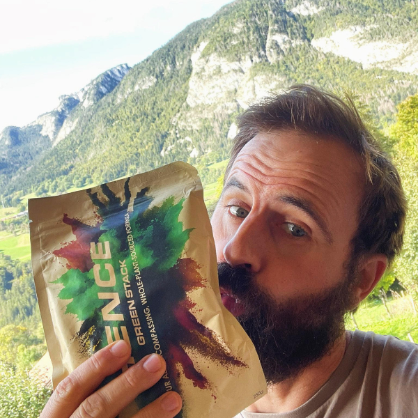 Man holding a Hence package with a mountainous landscape in the background