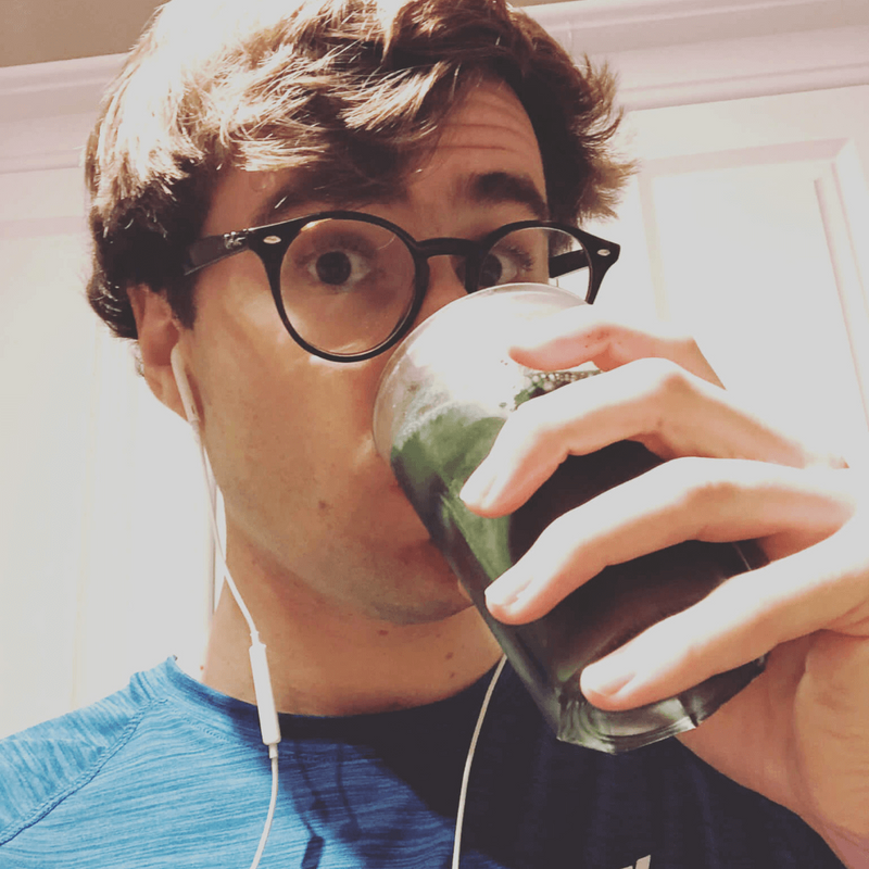 Man drinking a glass of Hence Greens — daily greens powder mixed and ready to go