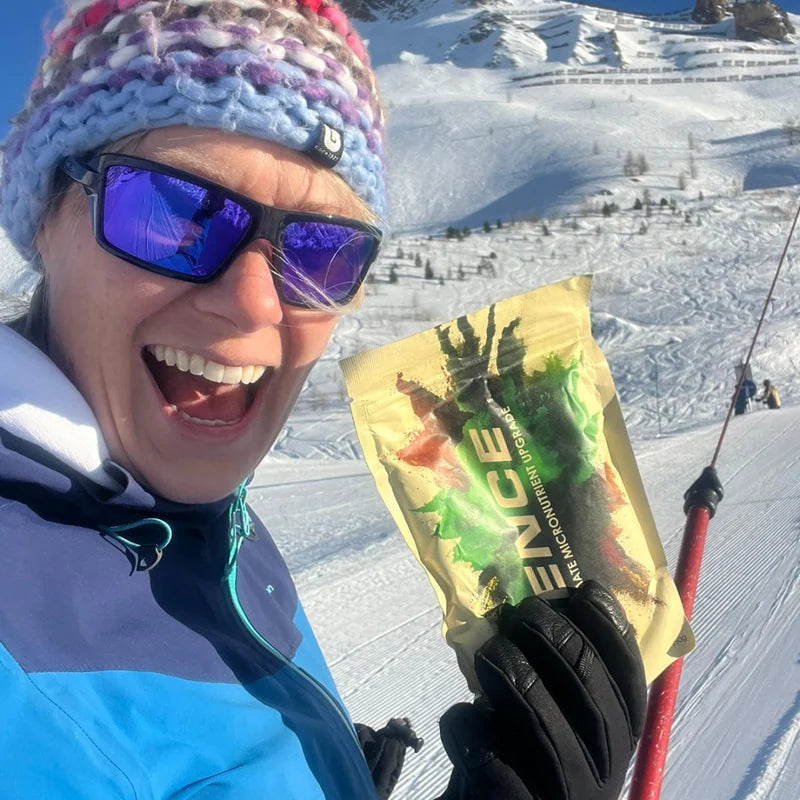 Customer holding a Hence Greens pouch on a snowy ski slope